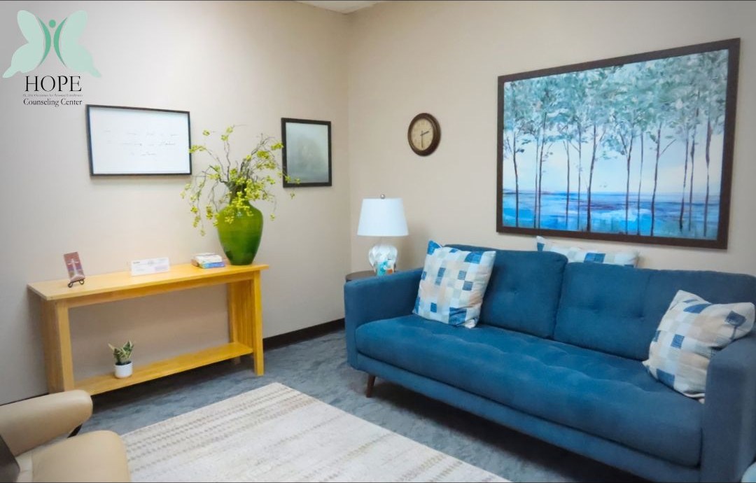 A counseling room with a soft blue couch and warm light.